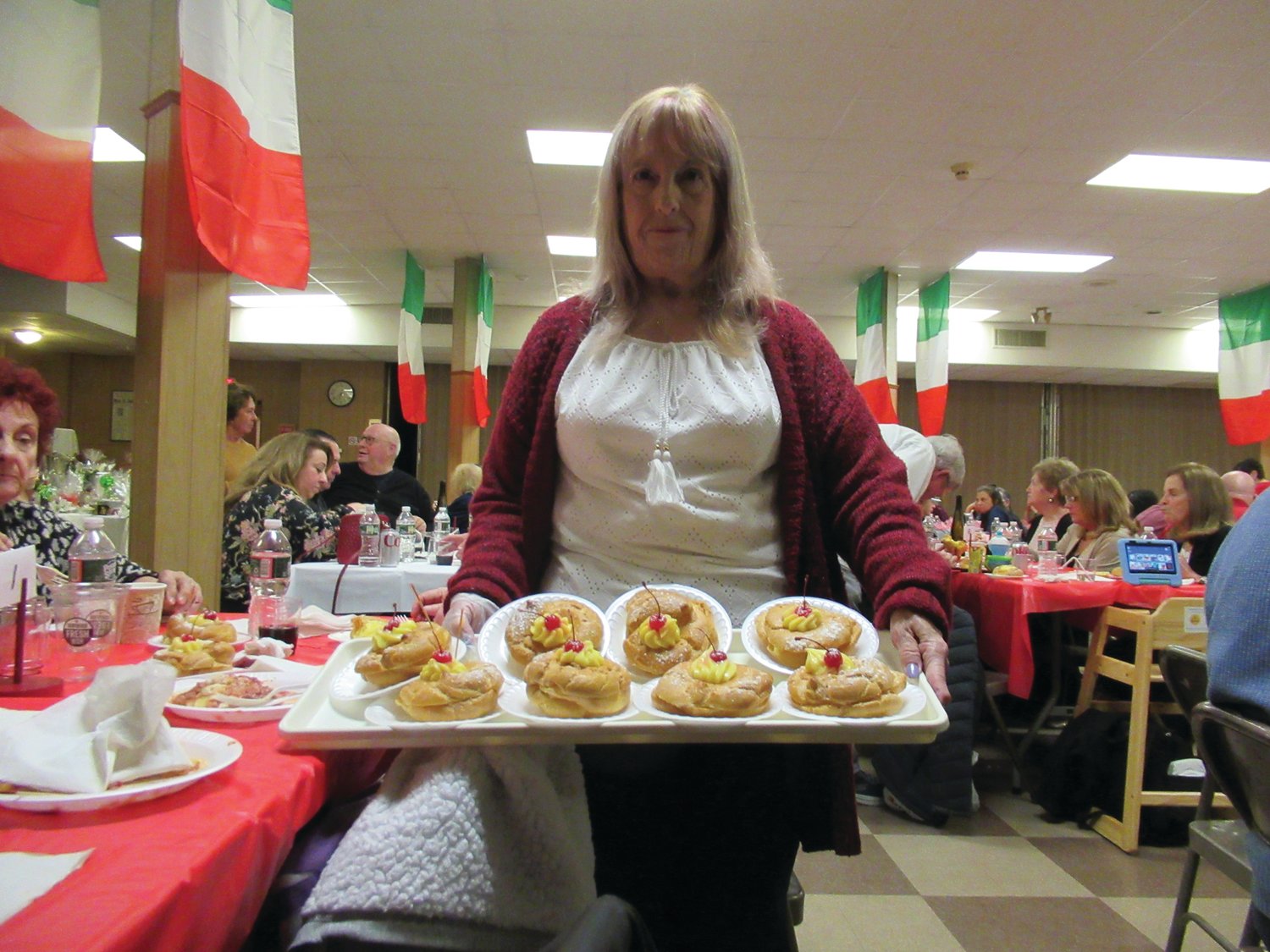 DELICIOUS DUTY: Debra St. Hilaire, one of the many dedicated parishioners at Our Lady of Grace Church, holds a tray of specially made Italian Zeppole as a crowd of 231 people enjoyed Saturday night inside Fioretti Hall.